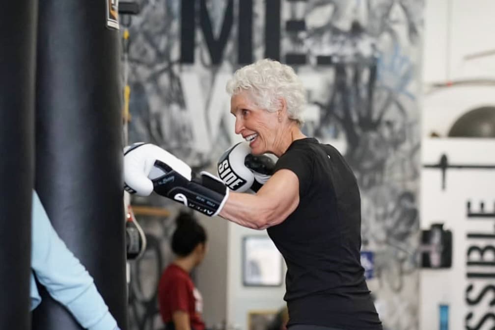 Rock Steady Boxing member punching a heavy bag